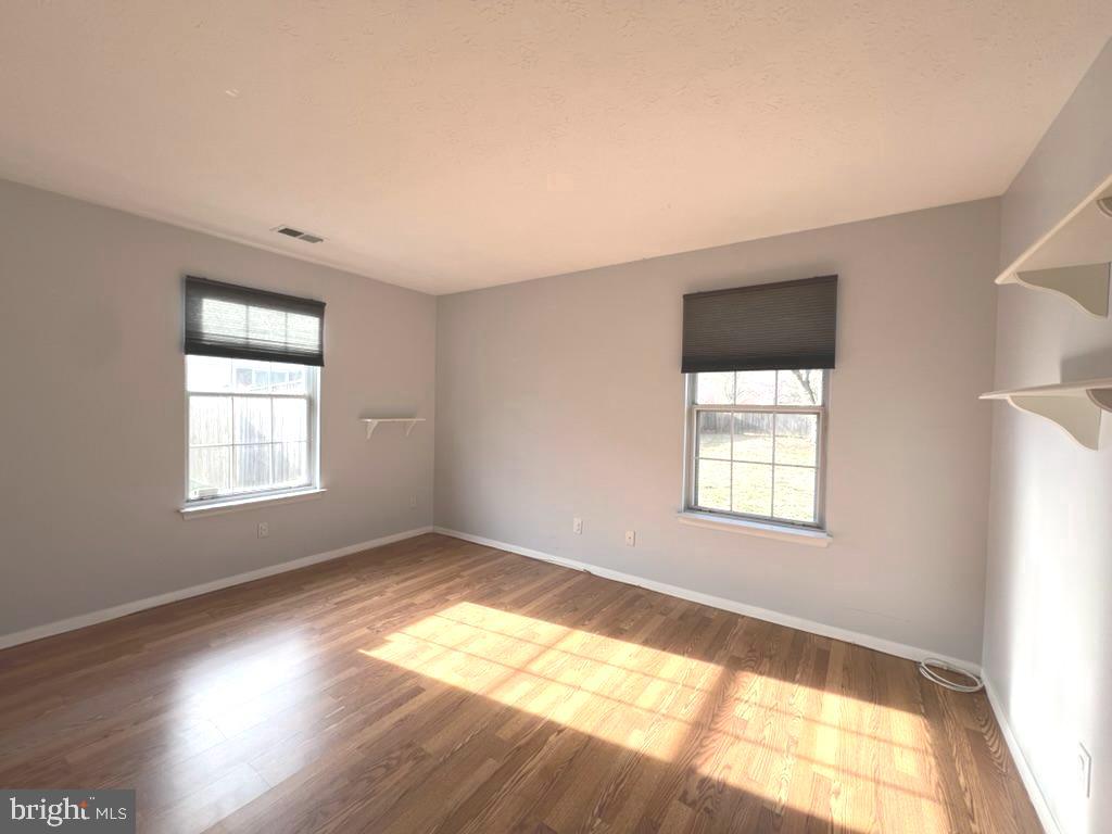 8220 Grainfield Road Severn, MD 21144 - Photo 14 of 23 a view of empty room with wooden floor and fan