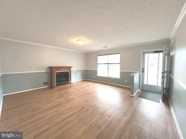 an empty room with wooden floor and fireplace
