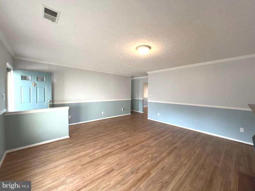 8220 Grainfield Road Severn, MD 21144 - Photo 4 of 23 a view of an empty room with wooden floor and a window