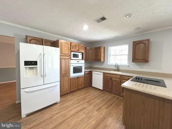 a kitchen with a refrigerator sink and cabinets