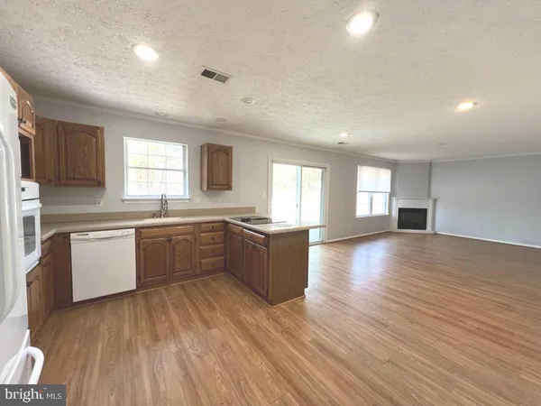 a large kitchen with a lot of counter space and wooden floor