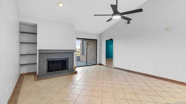 a view of an empty room with a fireplace and a window