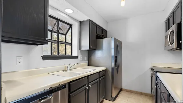 a kitchen with stainless steel appliances cabinets a sink and a refrigerator