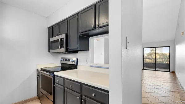 a kitchen with stainless steel appliances a sink a stove a microwave and cabinets