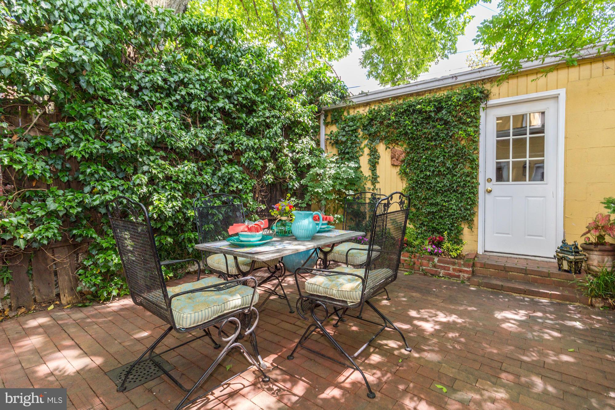 137 D Street Southeast Washington, DC 20003 - Photo 25 of 27 a backyard of a house with dining table and chairs with plants