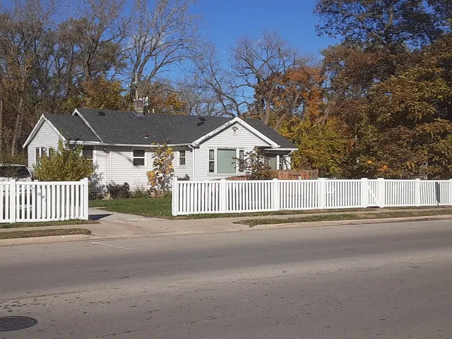 a view of a house with a small yard and wooden fence