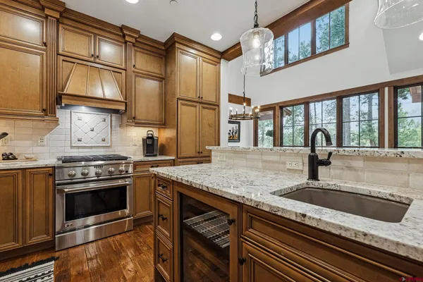 a kitchen with stainless steel appliances granite countertop a sink and a stove