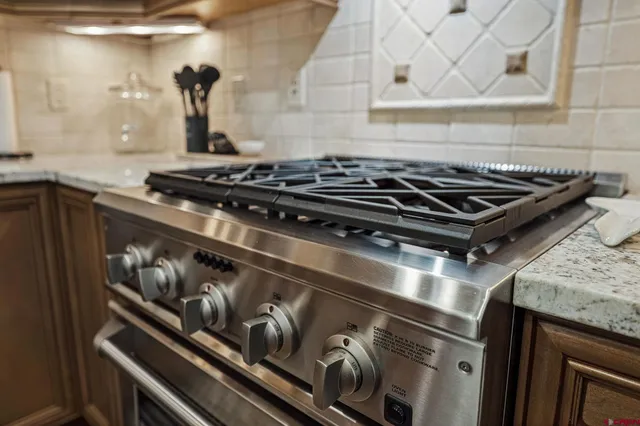 a stove sitting inside of a kitchen with granite countertop