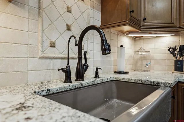 a kitchen with granite countertop a sink and a stove