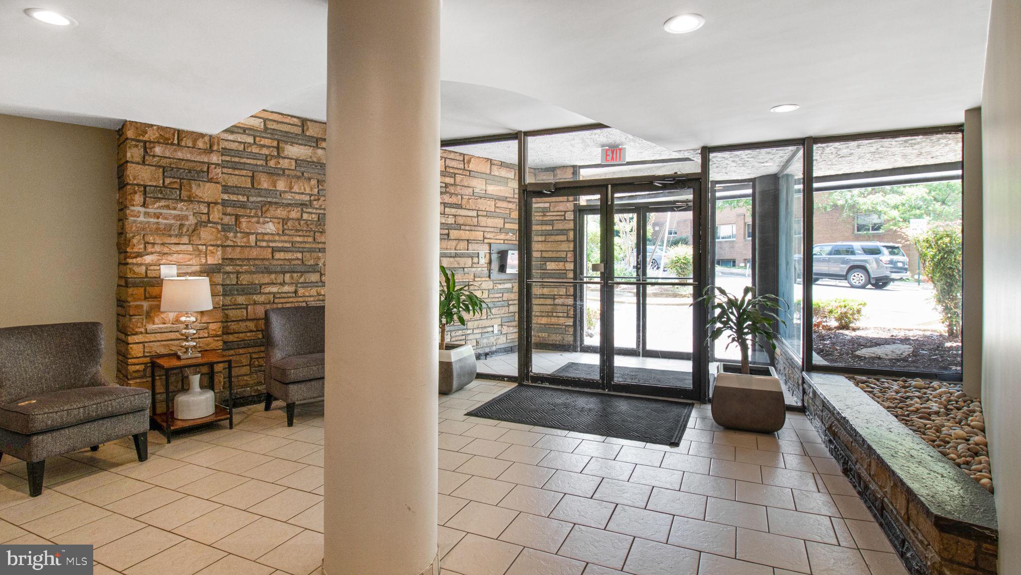3901 Tunlaw Road Northwest, Unit 701 Washington, DC 20007 - Photo 1 of 17 a hallway with a view of living room and wooden floor