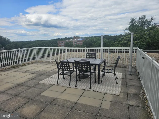 a view of a roof deck with table and chairs