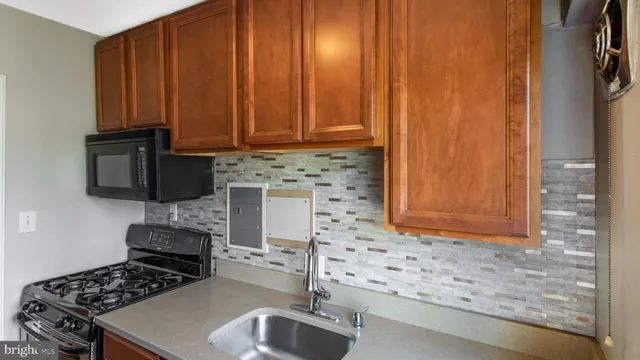 a kitchen with granite countertop a sink stove and cabinets
