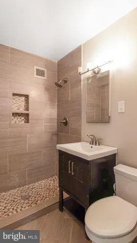 a bathroom with a sink a toilet and shower