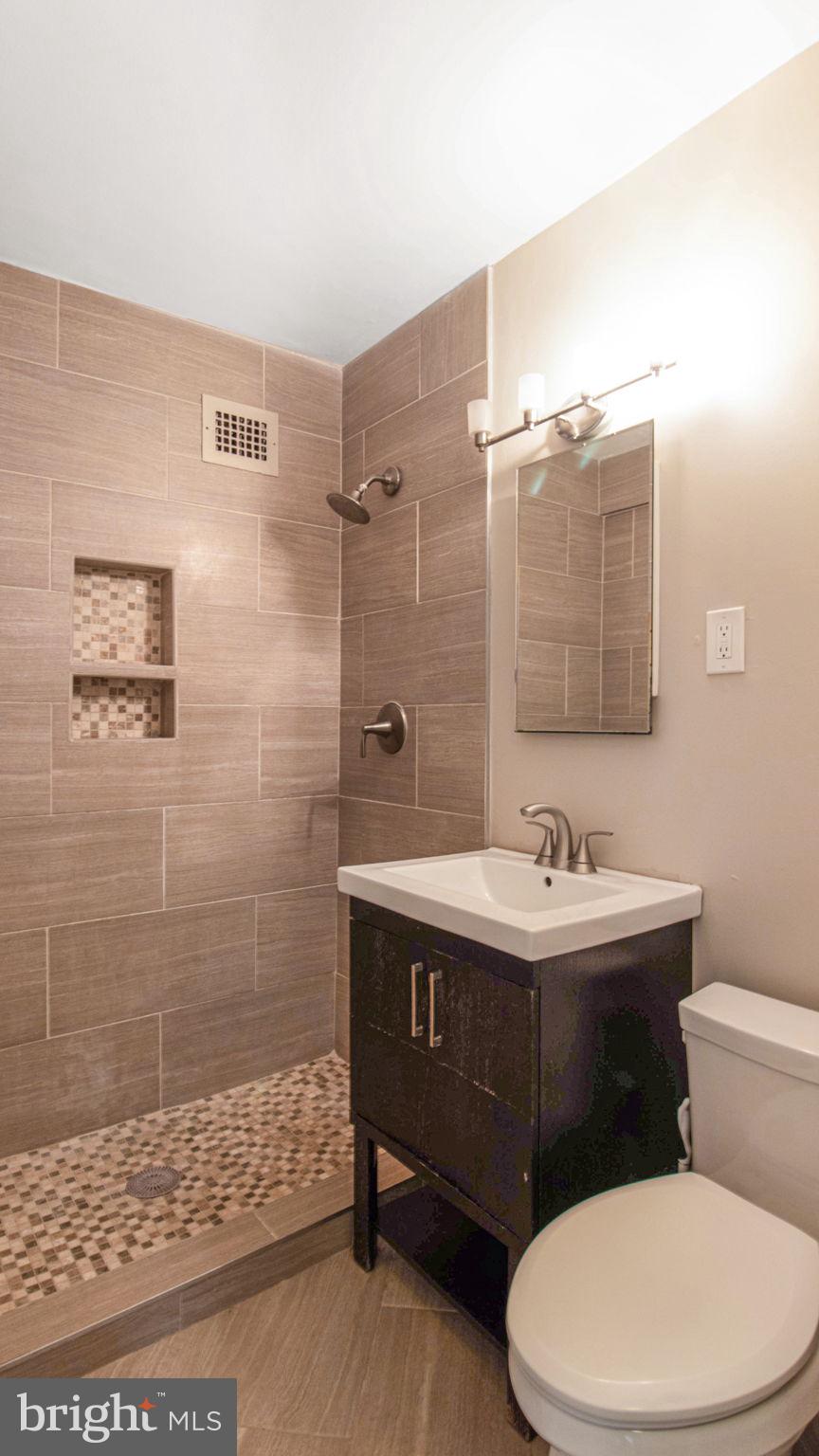 3901 Tunlaw Road Northwest, Unit 701 Washington, DC 20007 - Photo 10 of 17 a bathroom with a sink a toilet and shower