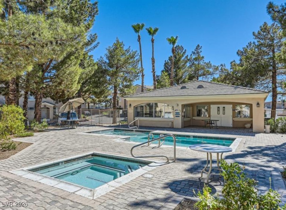 Community pool featuring a hot tub and a patio area