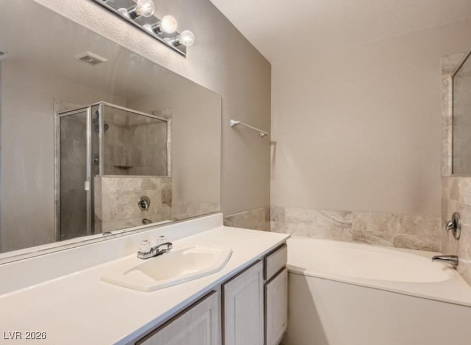 3950 South Sandhill Road, Unit 121 Las Vegas, NV 89121 - Photo 5 of 11 Bathroom featuring a bath, vanity, and a shower stall