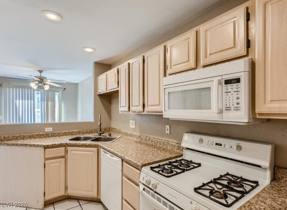 3950 South Sandhill Road, Unit 121 Las Vegas, NV 89121 - Photo 8 of 11 Kitchen with white appliances, light wood finish cabinets, light countertops, a ceiling fan, and recessed lighting