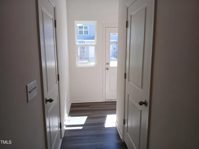 a view of a hallway with wooden floor and closet area