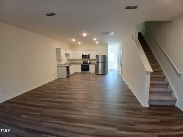 a view of a kitchen with wooden floor and electronic appliances