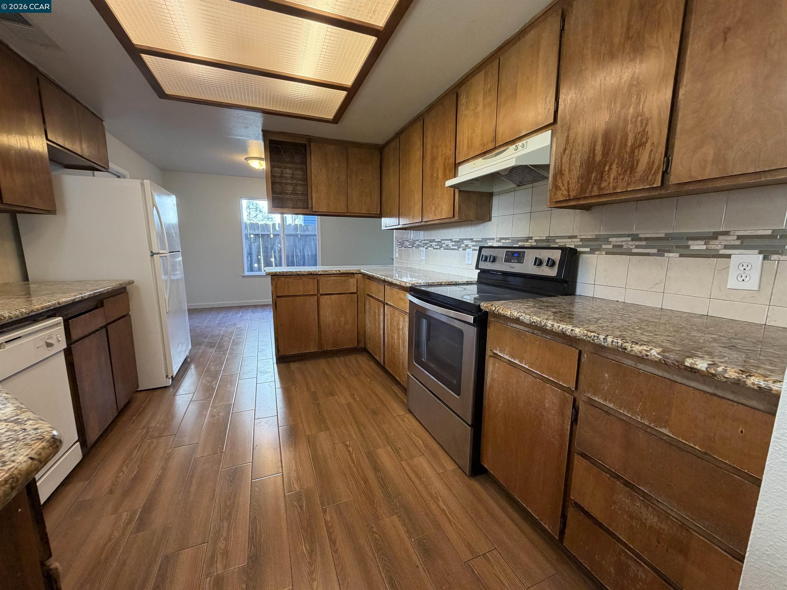 2510 Peppertree Drive Merced, CA 95348 - Photo 3 of 15 a kitchen with granite countertop wooden floors and stainless steel appliances