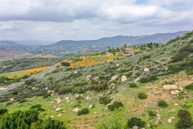a view of an aerial view of residential houses with swimming pool and mountains