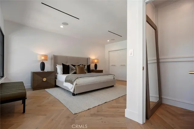 a bedroom with bed and a flat tv screen on dresser