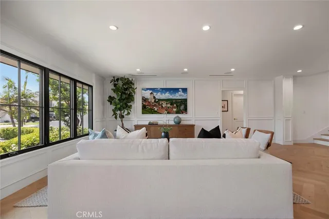a living room with couches and a view of kitchen