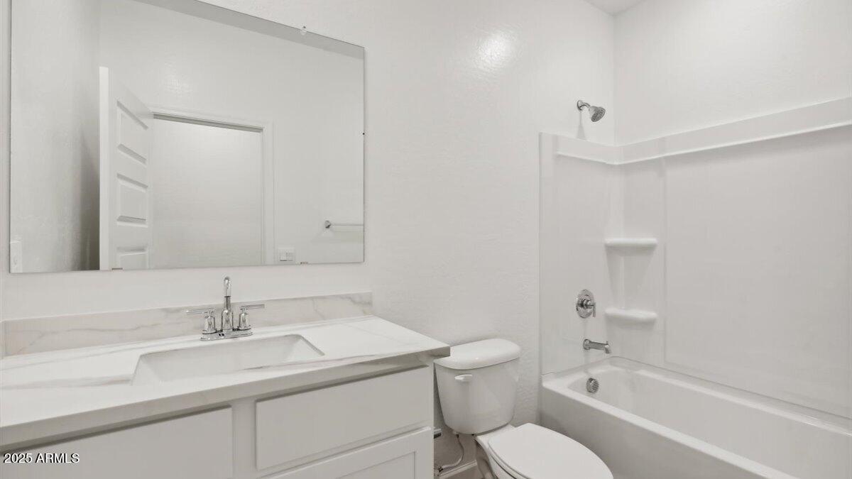 2095 West Starfire Avenue Apache Junction, AZ 85120 - Photo 19 of 24 a bathroom with a sink toilet vanity and shower