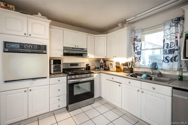 a kitchen with cabinets appliances a sink and a window