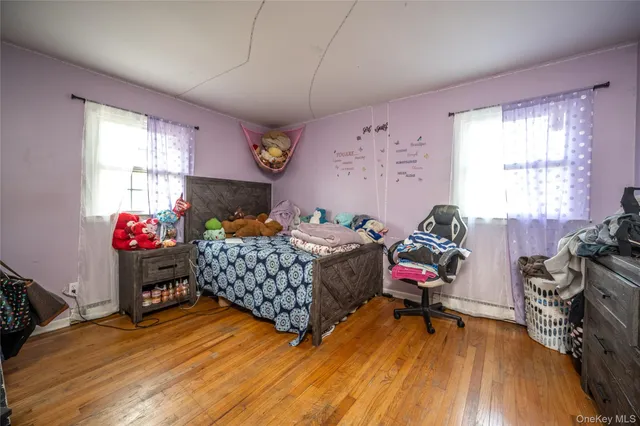 a bedroom with a bed and a wooden floor
