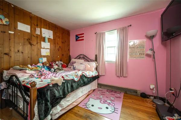 a bedroom with a bed window and flat screen tv