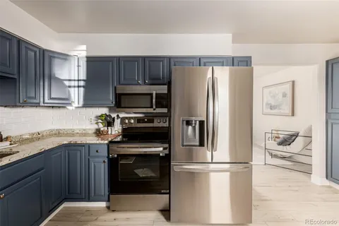 a kitchen with stainless steel appliances granite countertop a refrigerator stove a sink and dishwasher