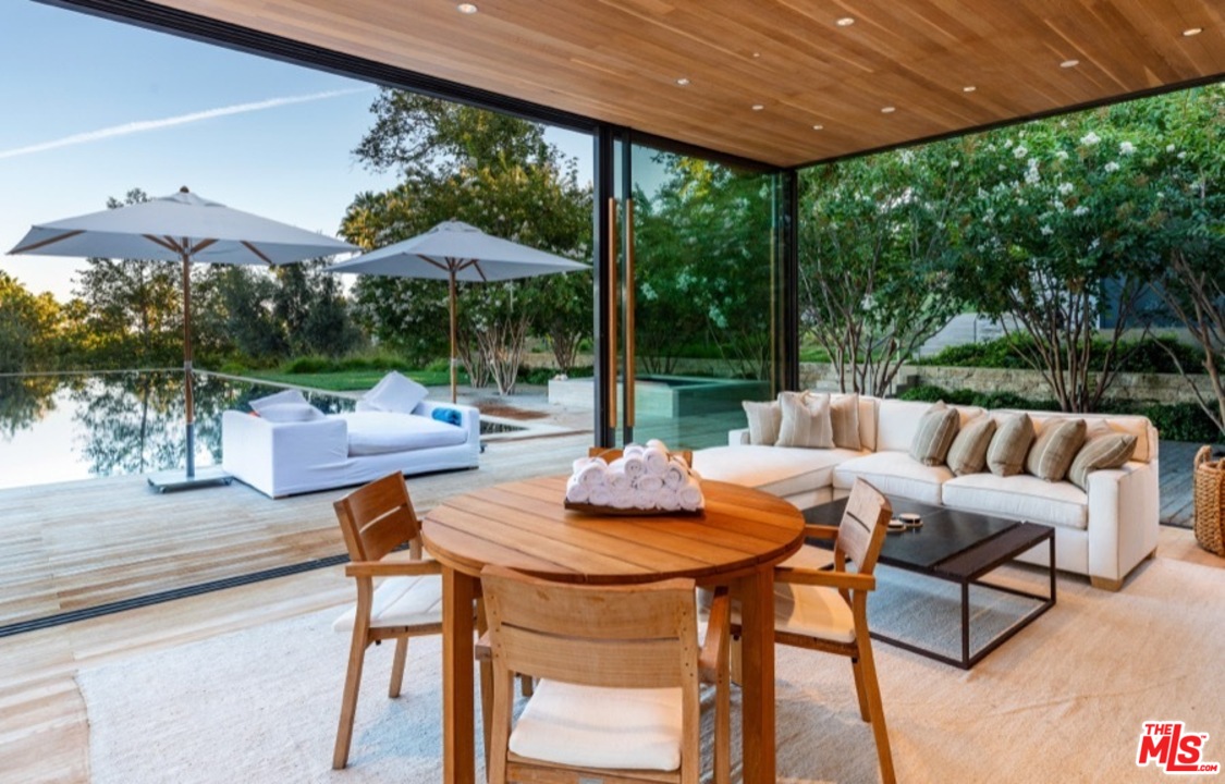 911 Foothill Road Beverly Hills, CA 90210 - Photo 18 of 21 a view of a patio with a table chairs and a backyard