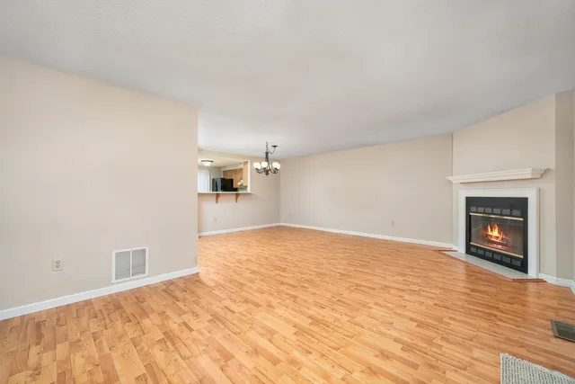 a view of empty room with wooden floor and fireplace