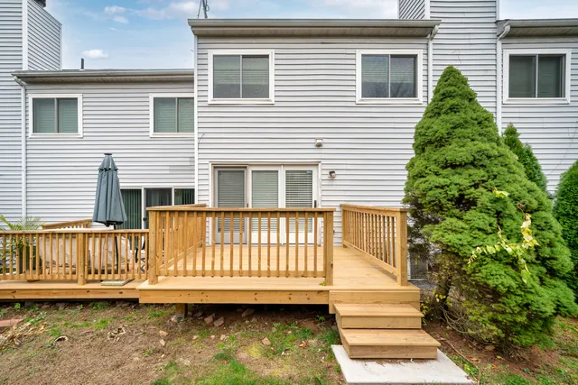 a view of a house with a small yard and wooden floor and fence