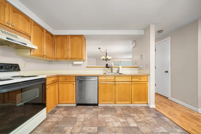 a kitchen with stainless steel appliances granite countertop a sink stove and cabinets