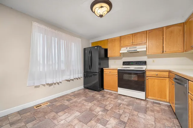 a kitchen with granite countertop a refrigerator and a sink