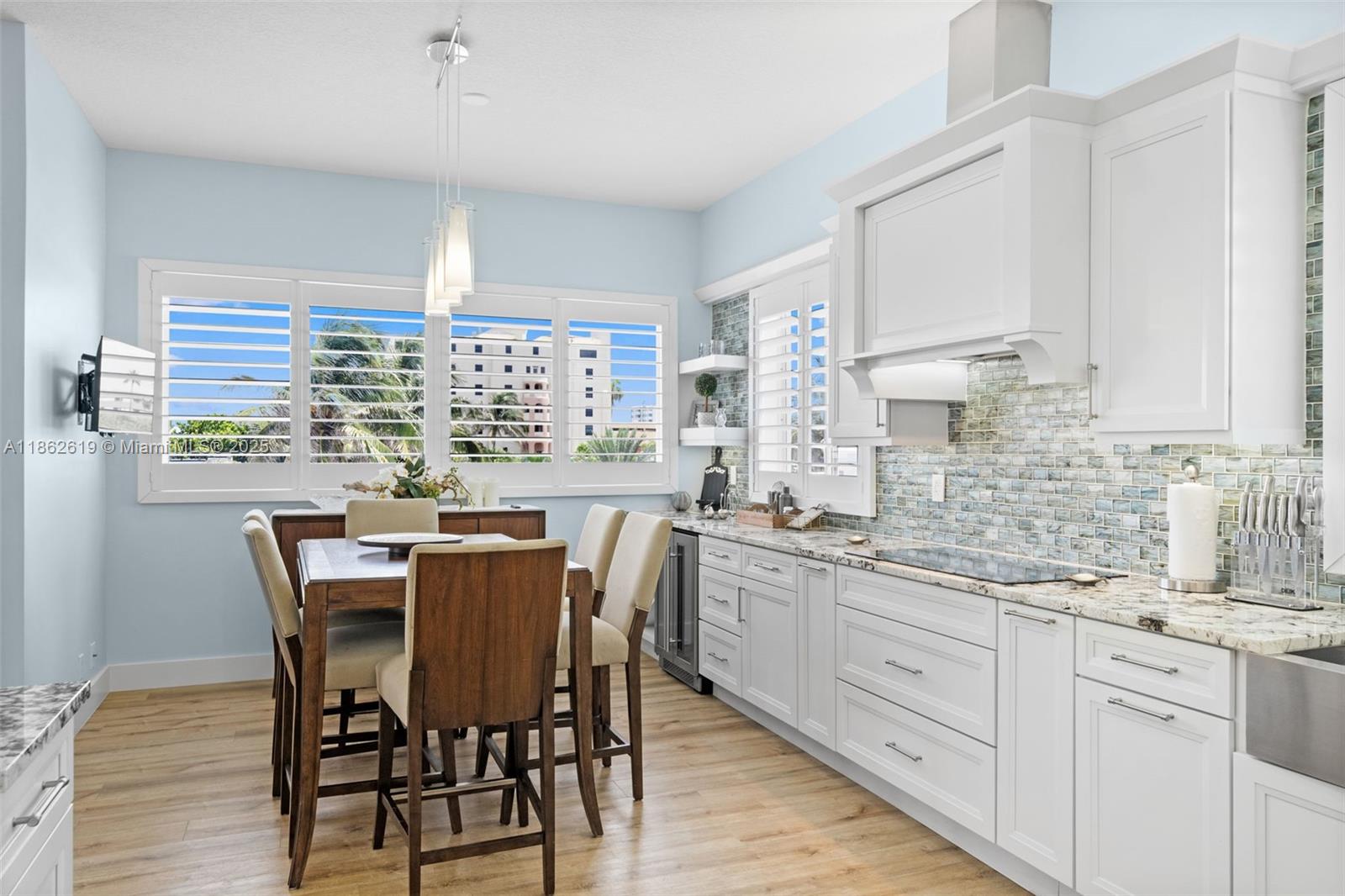 311 North Surf Road, Unit 311 Hollywood, FL 33019 - Photo 40 of 68 a kitchen with granite countertop a sink white cabinets and white appliances