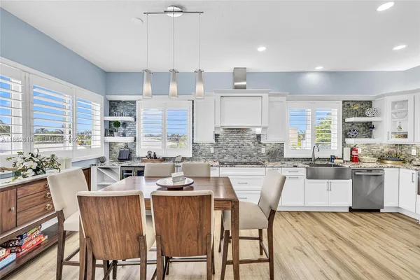 a kitchen with a stove a sink a kitchen island with a dining table and chairs