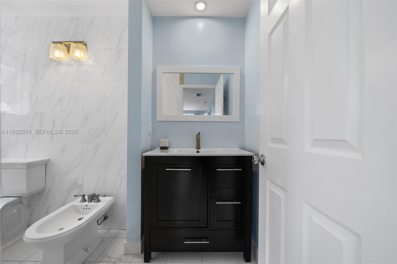 311 North Surf Road, Unit 311 Hollywood, FL 33019 - Photo 46 of 68 a bathroom with a sink a toilet and mirror