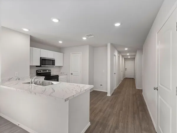 a view of kitchen with sink refrigerator and wooden floor