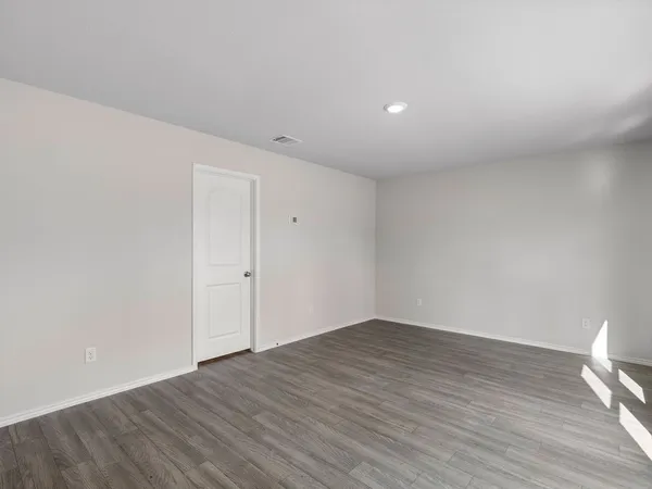 a view of an empty room with wooden floor