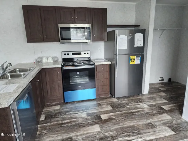 a kitchen with stainless steel appliances granite countertop a stove a refrigerator and a sink