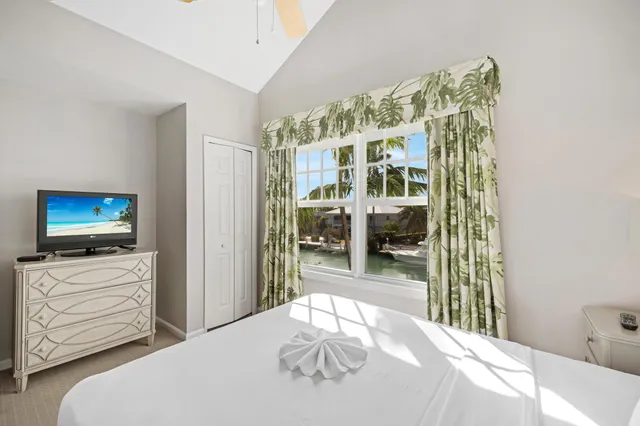 a bedroom with a large bed and a chandelier fan