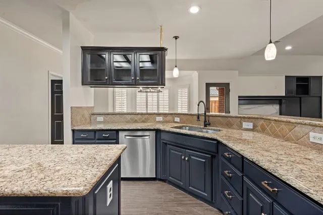 a kitchen with granite countertop kitchen island a sink stainless steel appliances and a counter space