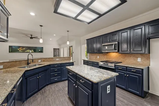 a kitchen with granite countertop stainless steel appliances and wooden cabinets