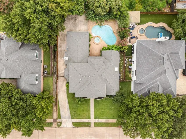 an aerial view of a house with a yard and a large tree