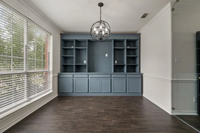 a view of empty room with wooden floor and windows