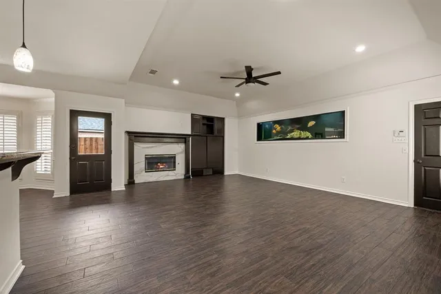 an empty room with windows and fireplace