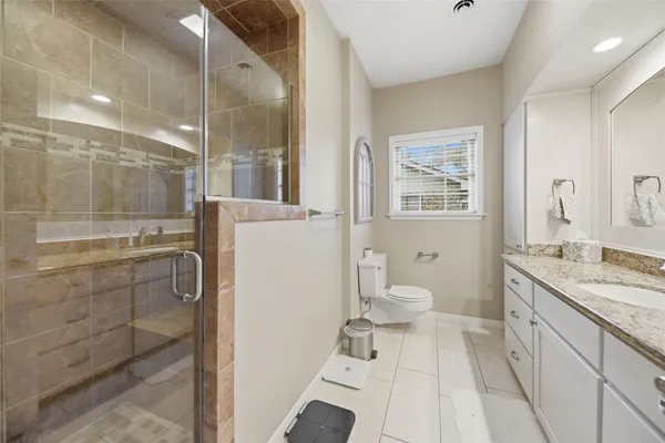 a bathroom with a granite countertop toilet a sink and a shower